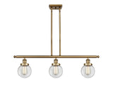 916-3I-BB-G202-6 3-Light 36" Brushed Brass Island Light - Clear Beacon Glass - LED Bulb - Dimmensions: 36 x 6 x 10<br>Minimum Height : 19.375<br>Maximum Height : 43.375 - Sloped Ceiling Compatible: Yes
