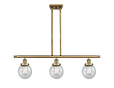 916-3I-BB-G204-6 3-Light 36" Brushed Brass Island Light - Seedy Beacon Glass - LED Bulb - Dimmensions: 36 x 6 x 10<br>Minimum Height : 19.375<br>Maximum Height : 43.375 - Sloped Ceiling Compatible: Yes